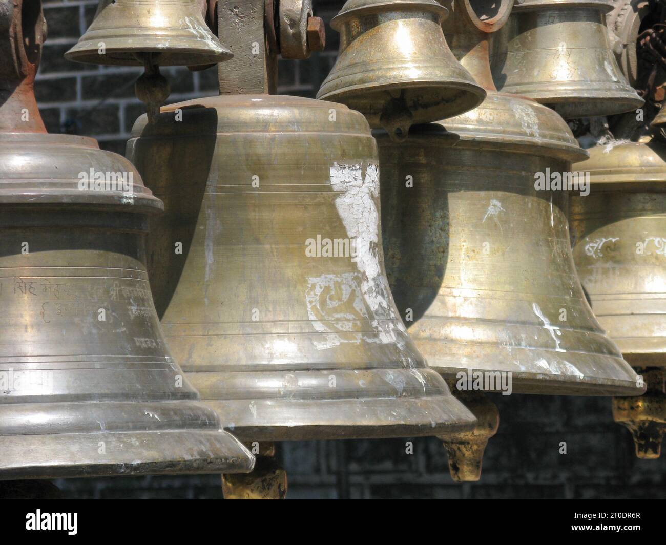 Selective focus image of Bells made of various metals hanging side by