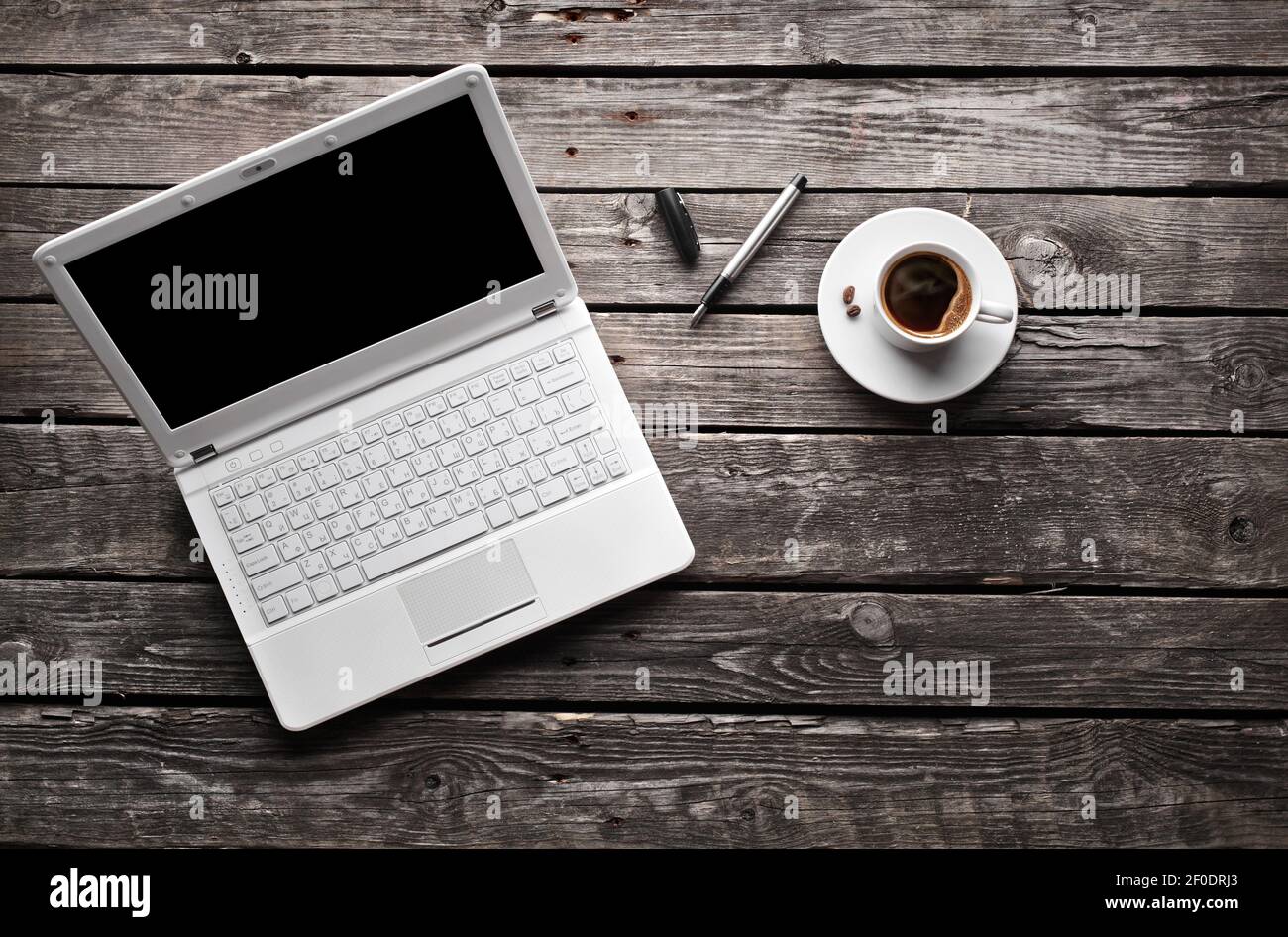 White laptop with coffee cup and pen Stock Photo