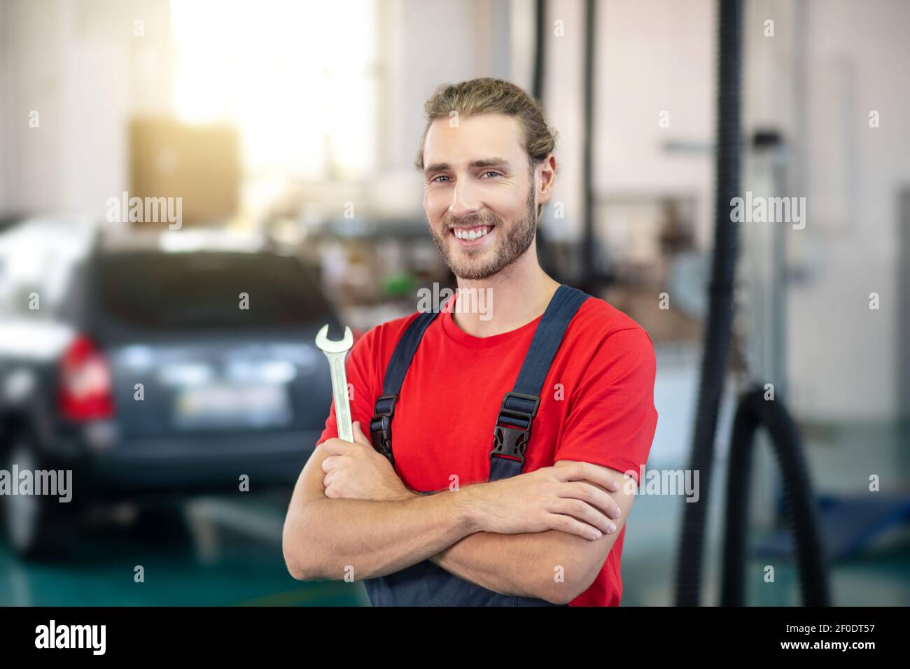 Joyful man motor mechanic standing in workshop Stock Photo