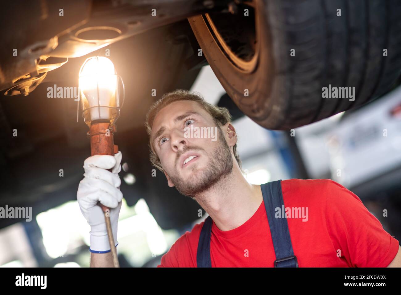 Man concentrating on the bottom of car Stock Photo