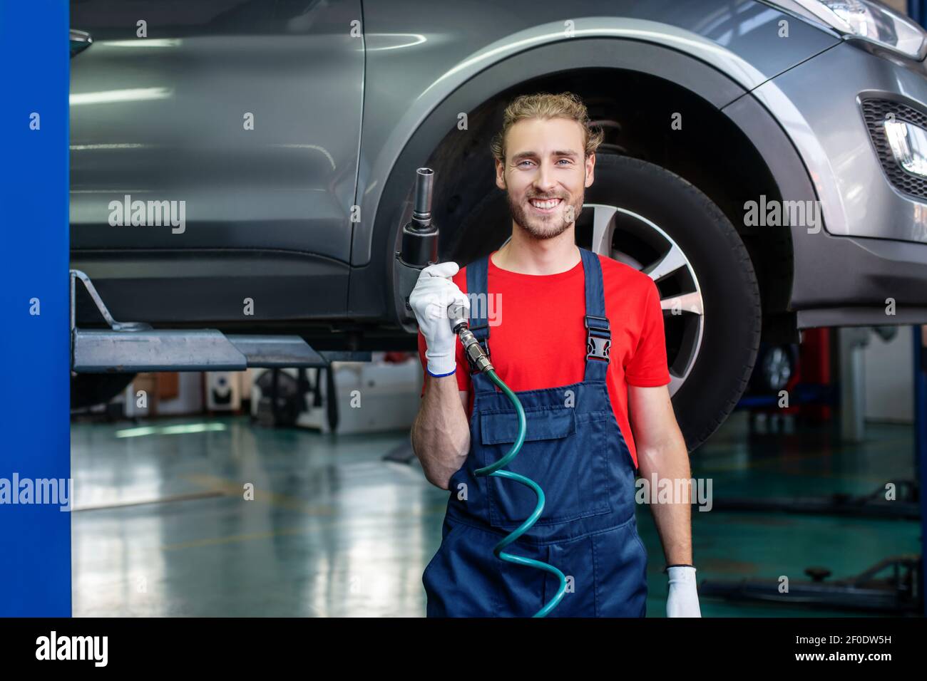 Happy man with work tool in garage Stock Photo