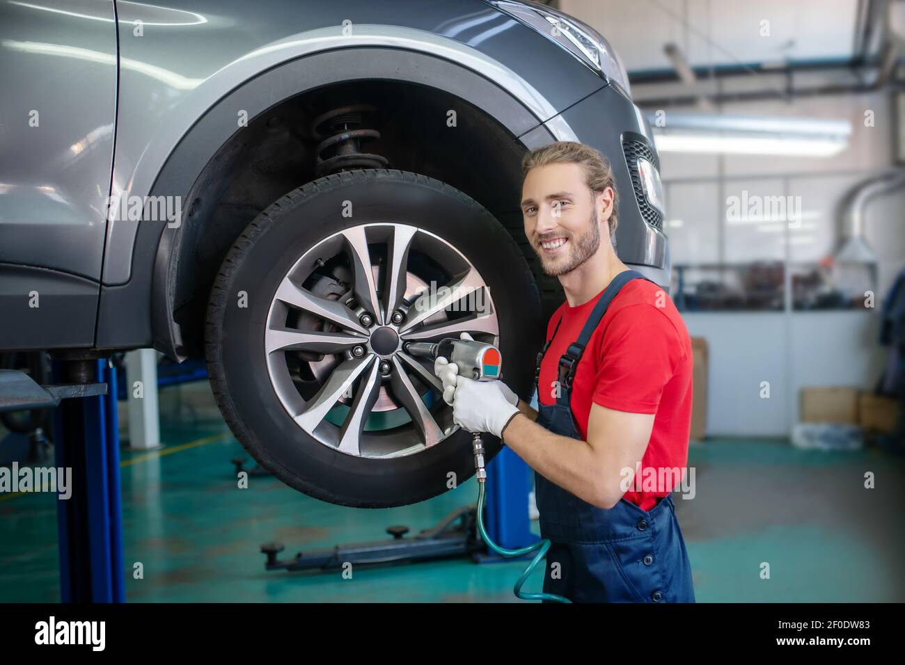 Man in uniform repairing a car Stock Photo
