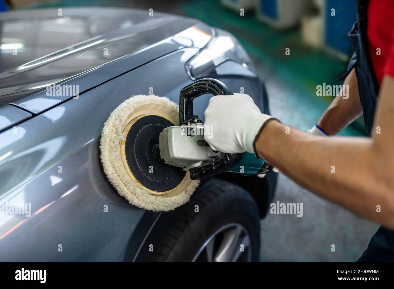 Male hands with polishing machine on surface of car Stock Photo