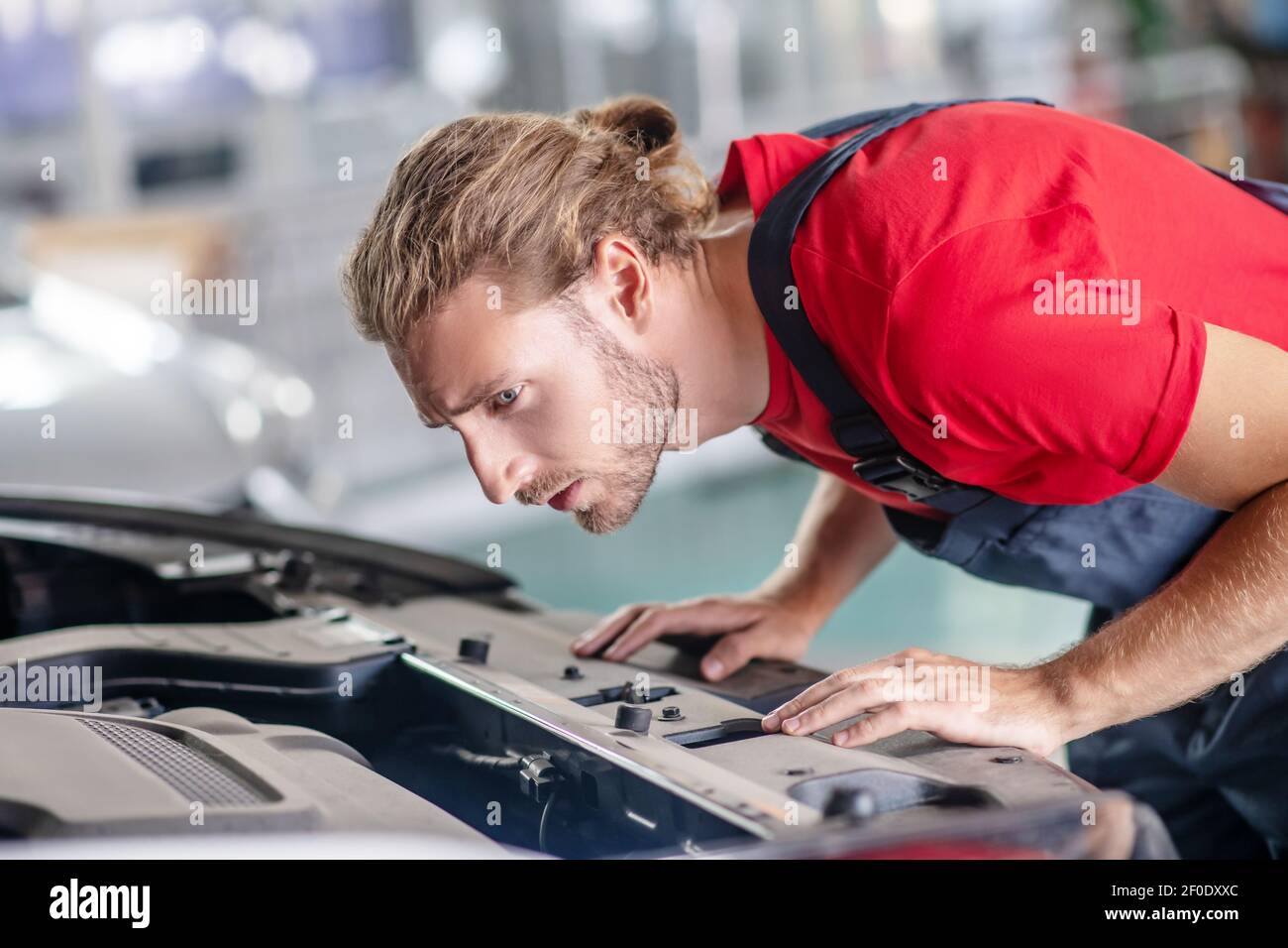 Man bent over open hood of car Stock Photo Alamy