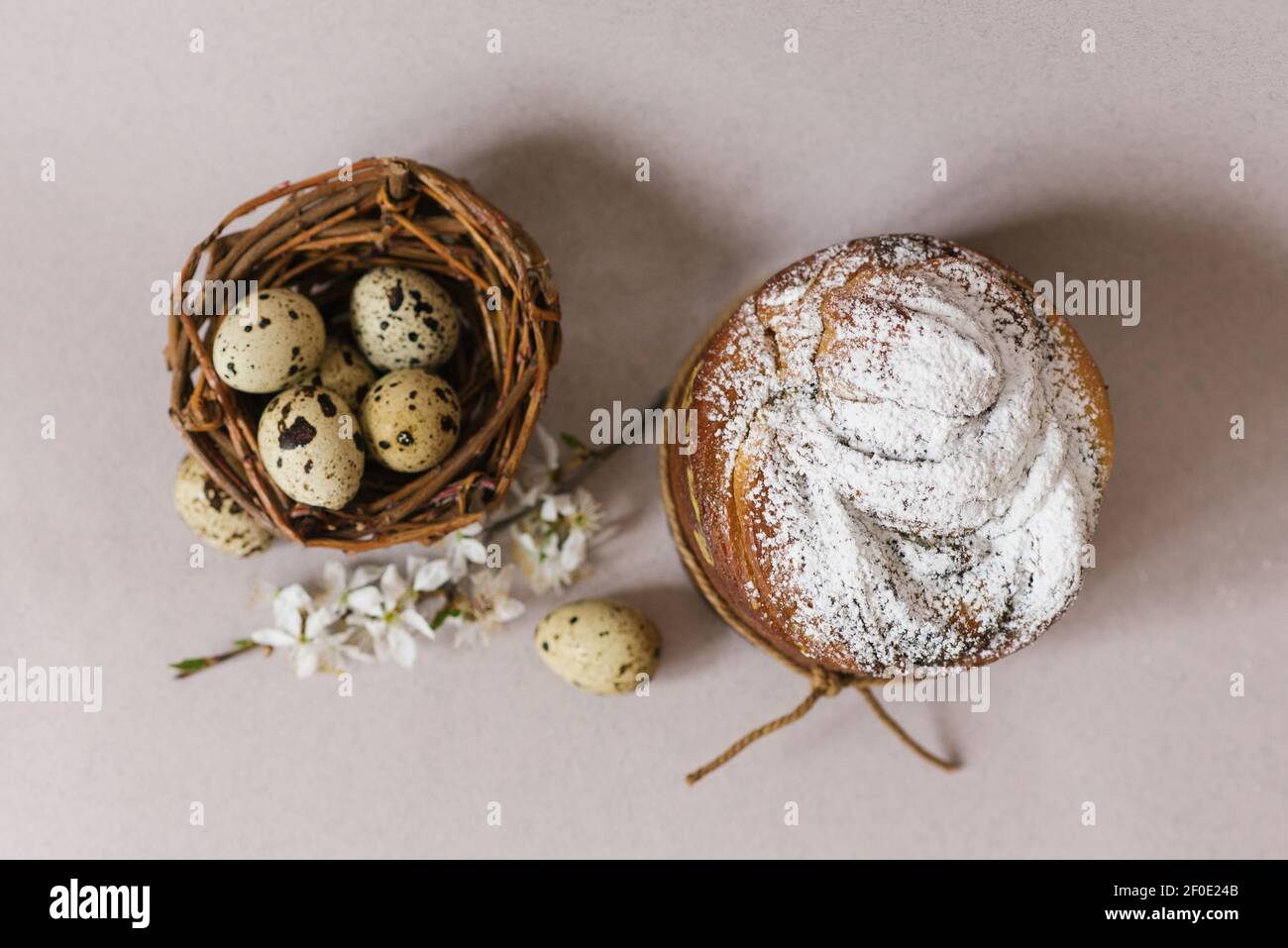Beautiful Easter composition with quail eggs, Easter cake, the cherry blossoms are traditionally elegant. Flat lay Stock Photo