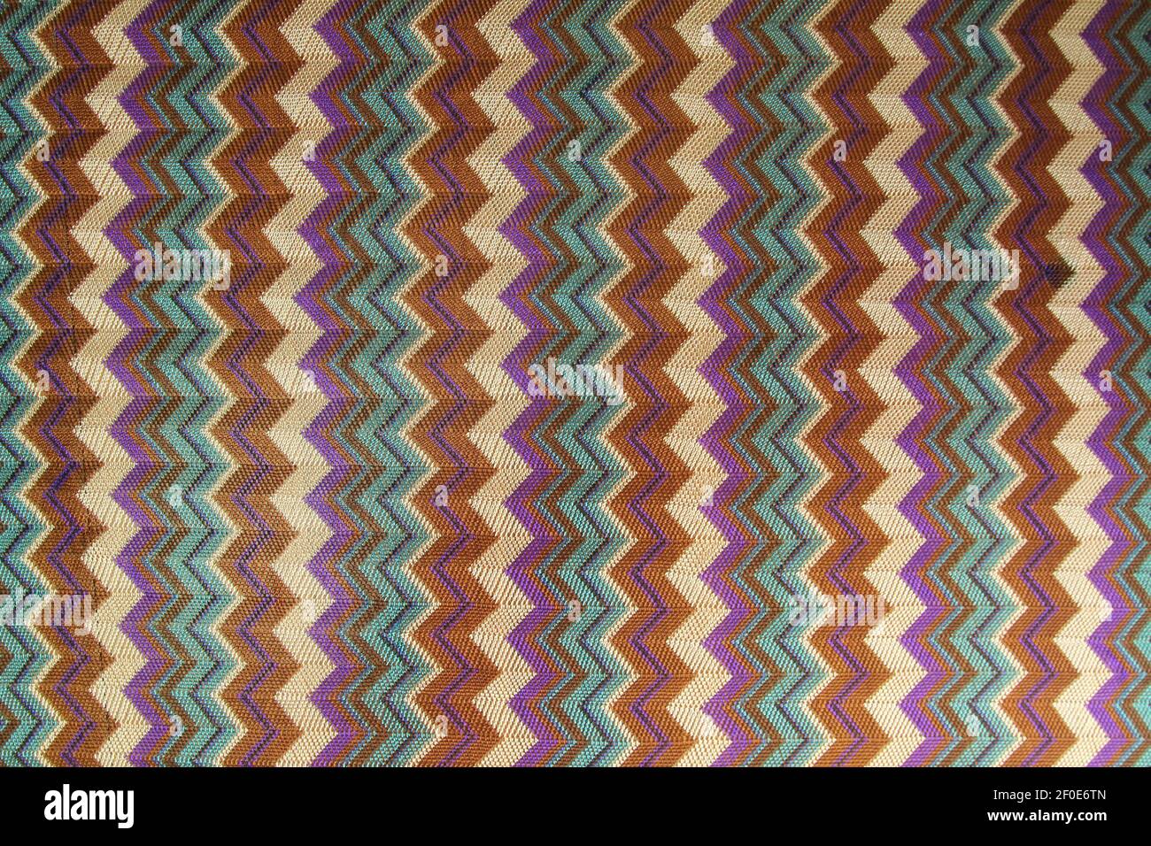 The pattern on the knitted fabric is a herringbone made of multi-colored stripes. Stock Photo
