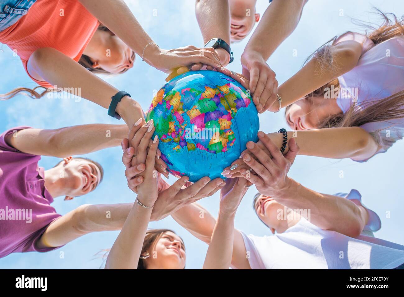 The concept of saving the world. A group of friends hold the world ...