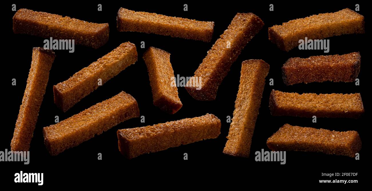 Rye bread croutons on black background, collection Stock Photo