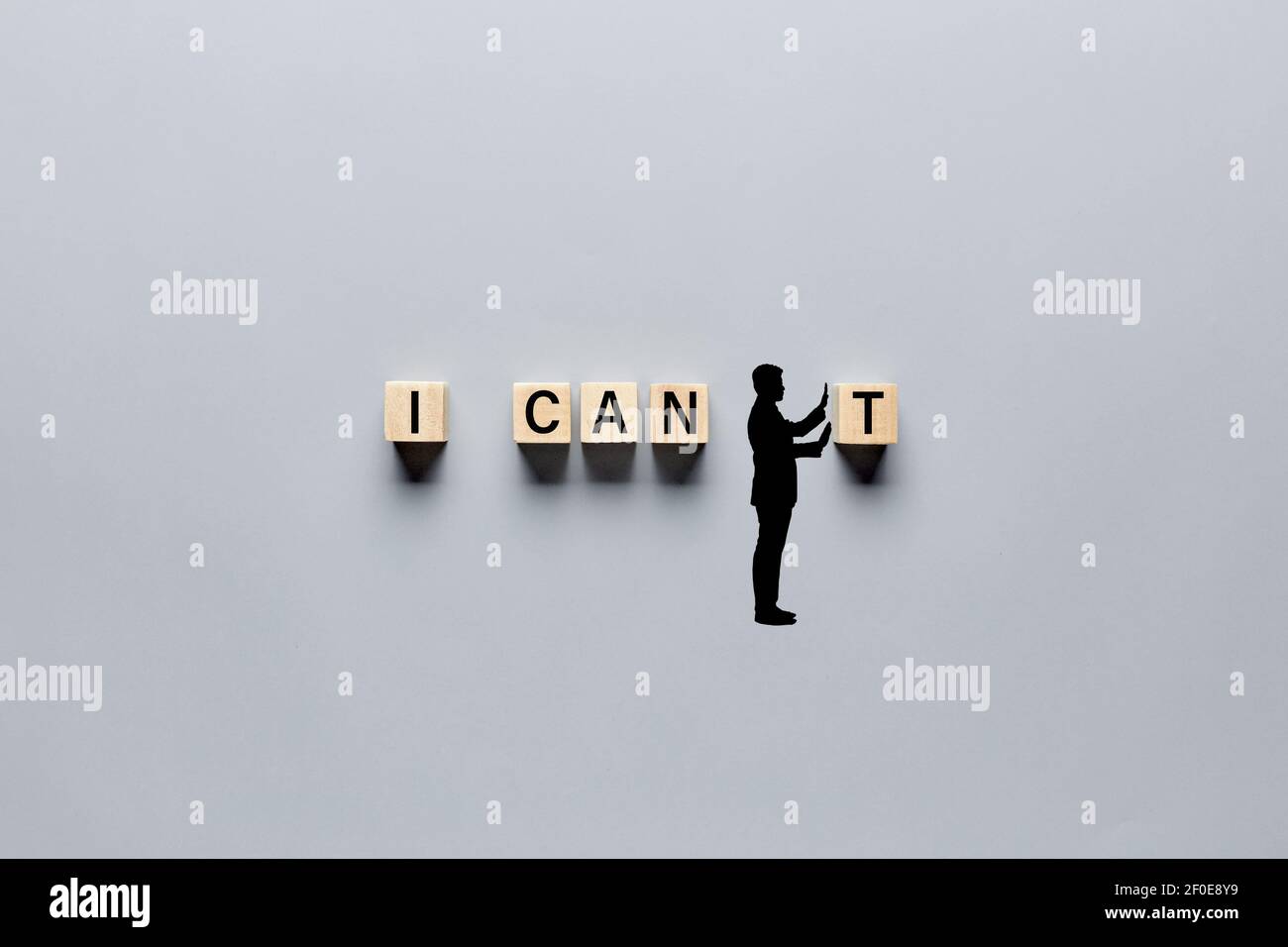 Silhouette of a hand drawn man changing the word I can't into I can by pushing away the letter. Aspiration, positivity, belief and motivation concept Stock Photo
