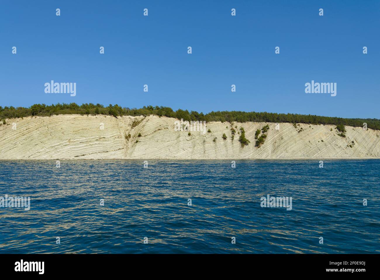 View of the steep wooded shore from the sea Stock Photo