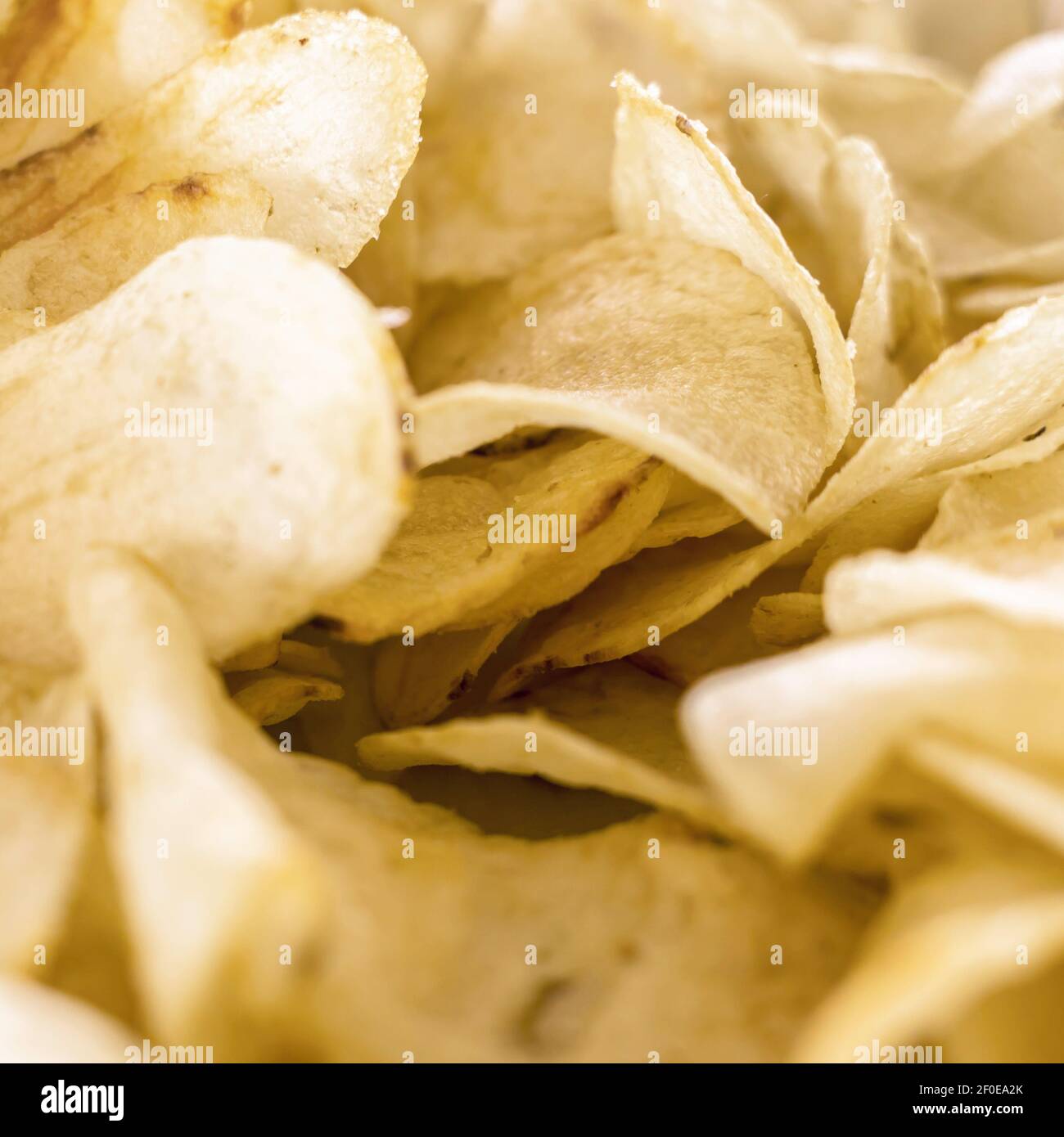 Yellow salted potato chips as background. Crispy chips golden pattern