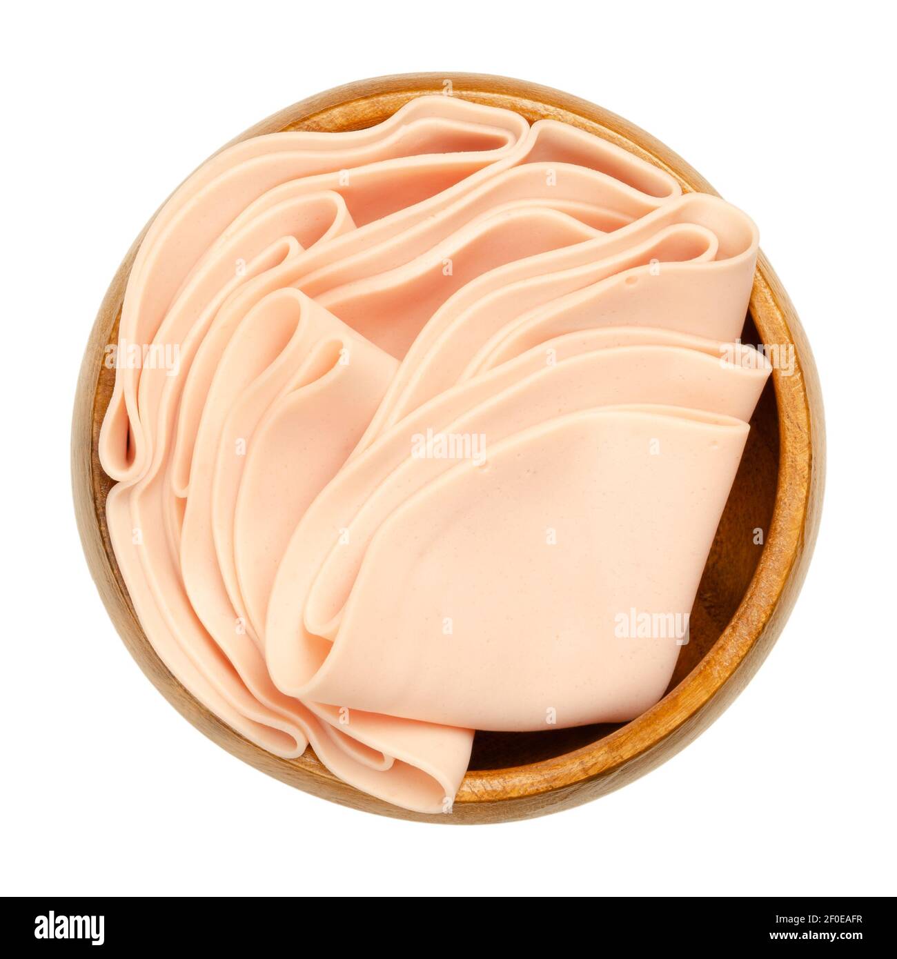 Vegetarian sausage, cold cut, in a wooden bowl. Thin slices of meatless Extrawurst, similar to Lyoner or Bologna sausage. Stock Photo