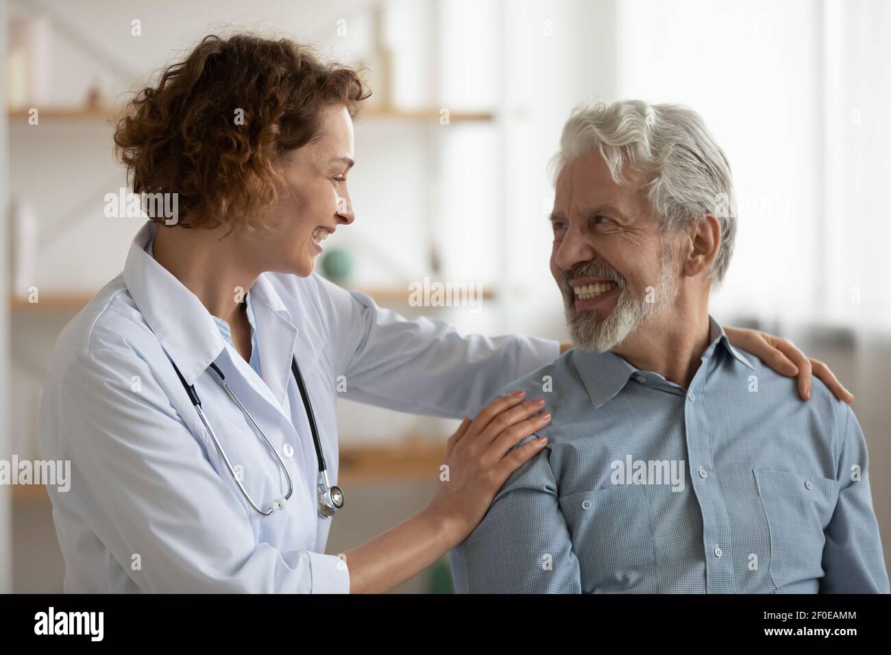 Happy female nurse comfort mature man patient Stock Photo - Alamy