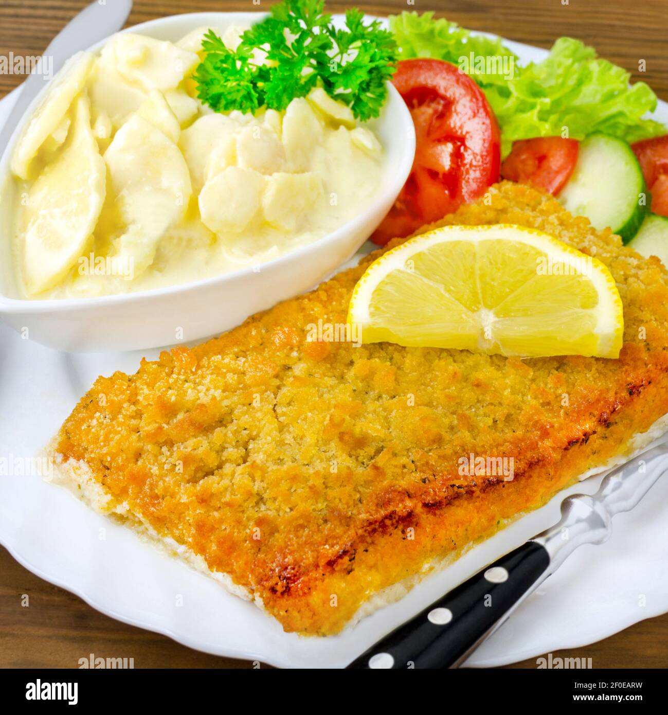 Potato salad and baked fish Stock Photo