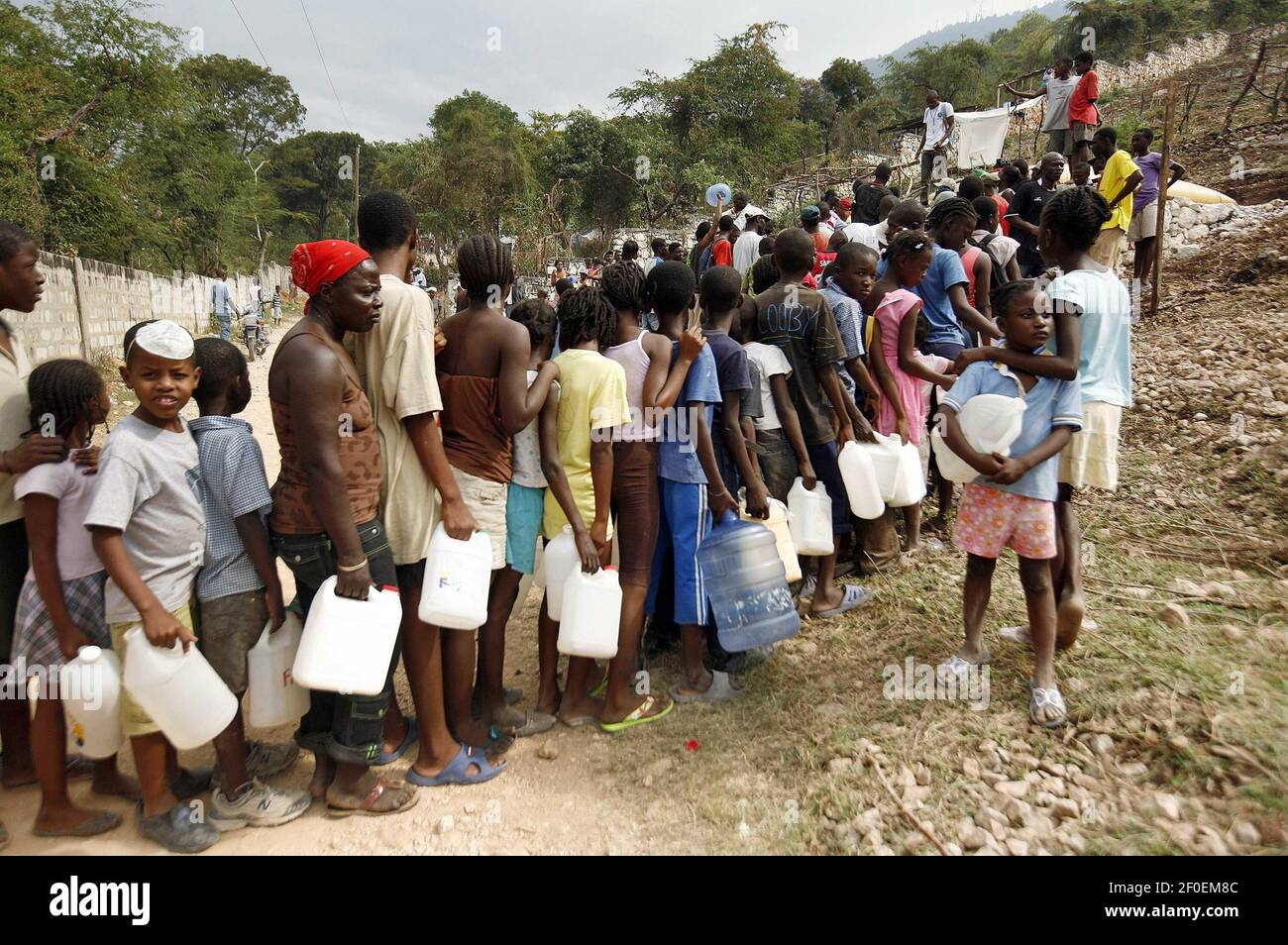 26 January 2010 - Carrefour-Feuilles, Haiti - Haitians queue for water in Tapis Rouge, a neighbourhood in the Carrefour-Feuilles area of Haiti's capital city, Port-au-Prince. Carrefour-Feuilles, a slum that stretches into the high mountains surrounding the city, has received little assistance since Haiti's earthquake. Photo Credit: UN Photo/Sophia Paris/Sipa Press***EDITORIAL USE ONLY***/1001282033 Stock Photo