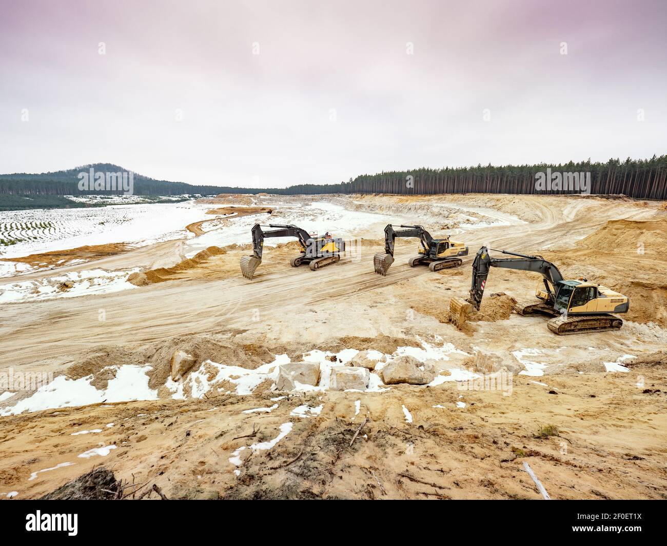 Large yellow black excavators in glass sand quarry for quarrying with