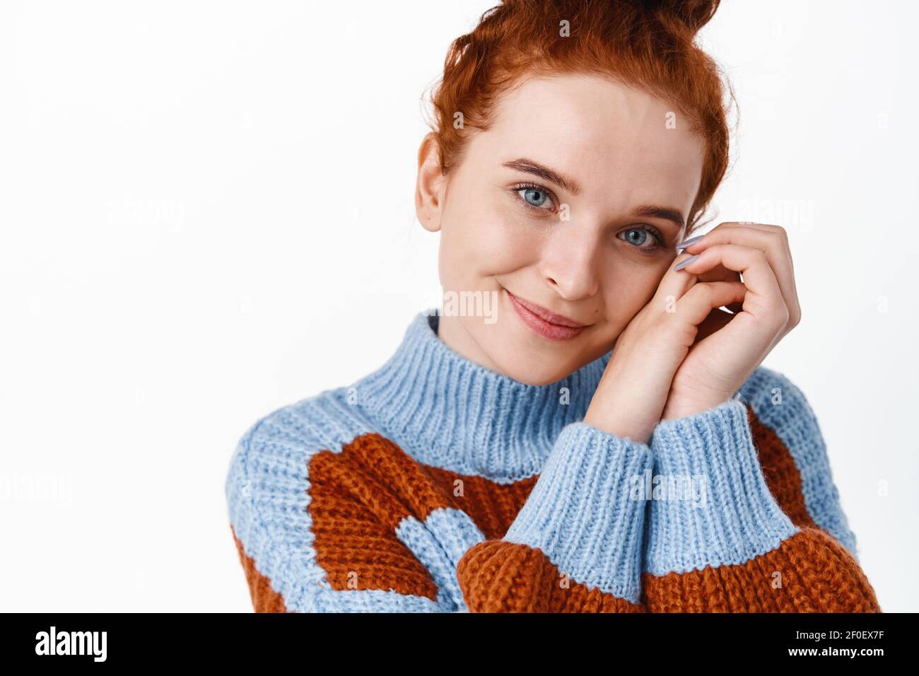 Close up portrait of beautiful redhead woman face with pale skin, no blemished and natural make up, smiling lovely and romantic, gazing at you, white Stock Photo