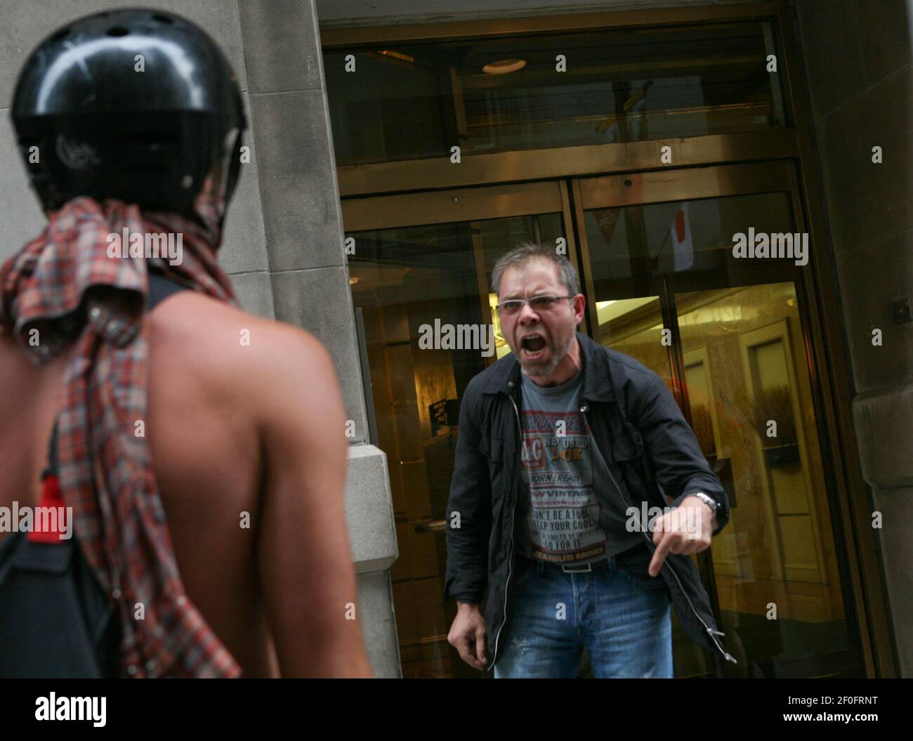 26 June 2010 - Toronto, Canada - Large groups of police dressed in riot gear starting taking control of downtown streets confronting protesters who have been marching through the streets against the G8 and G20 Summits. A local resident is seen here yelling at a protester for causing trouble during the summits. Photo Credit: Gary Fabiano/Sipa Press/G20Protest.005/1006270112 Stock Photo