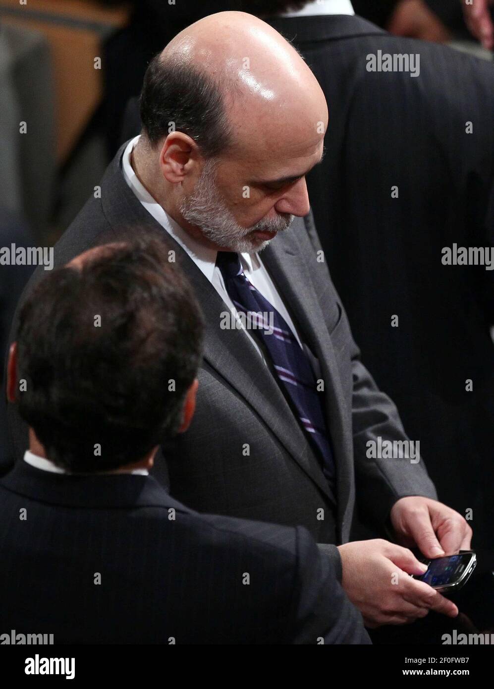 21 July 2010 - Washington, D.C. - Federal Reserve Chairman Ben Bernanke checks his phone before U.S. President Barack Obama signed the Dodd-Frank Wall Street Reform and Consumer Protection Act at the Ronald Reagan Building July 21, 2010 in Washington, DC. The bill is the strongest financial reform legislation since the Great Depression and also creates a consumer protection bureau that oversees banks on mortgage lending and credit card practices. Photo Credit: Win McNamee/Pool/Sipa Press/1007211950 Stock Photo
