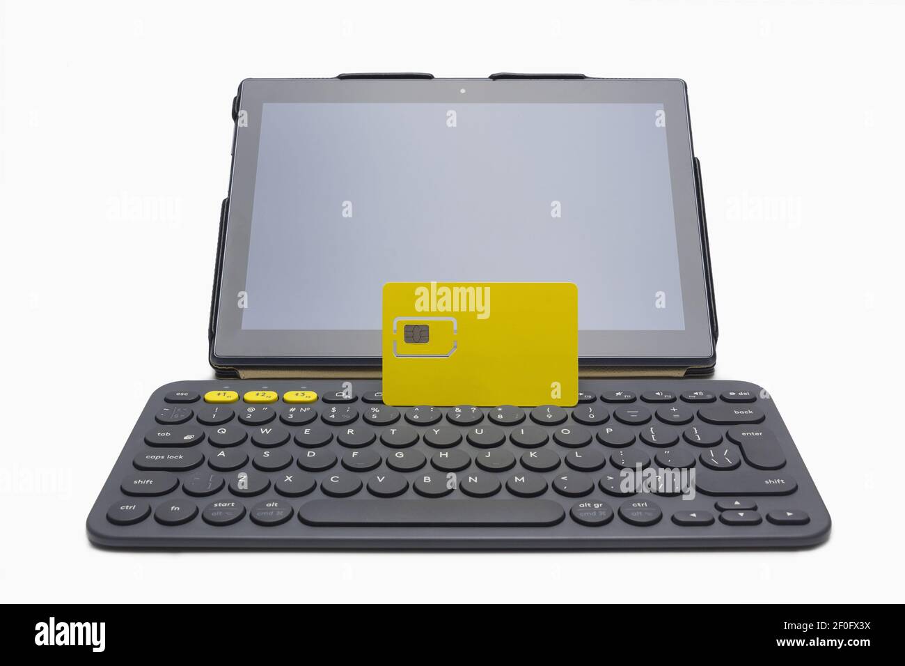 Tablet computer, yellow sim card and small wireless keyboard Stock Photo