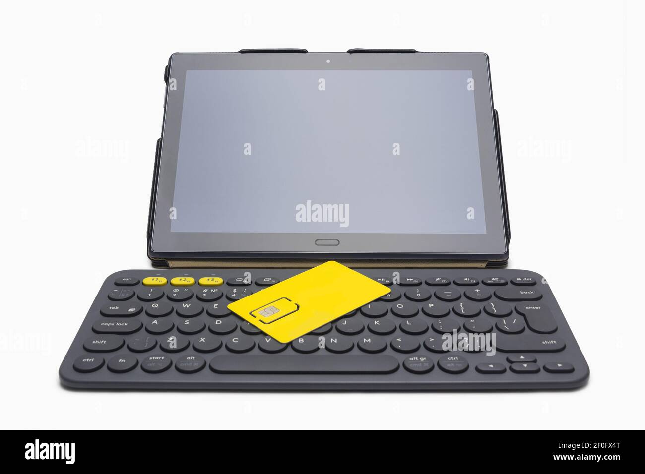 Tablet computer, yellow sim card on wireless keyboard Stock Photo