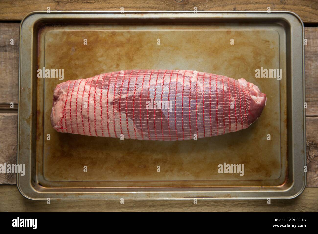 A raw British beef roasting joint on a metal baking tray. England UK GB