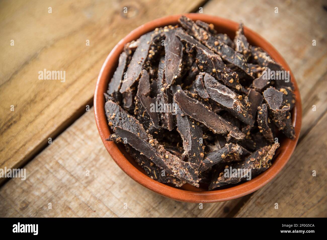 A bowl of chopped biltong made from fallow deer venison that has been air dried and cured using salt, vinegar and sugar and various spices including c Stock Photo