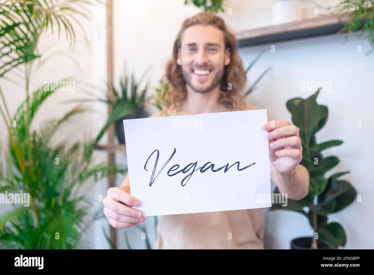 Poster with word vegan in mans outstretched hands Stock Photo