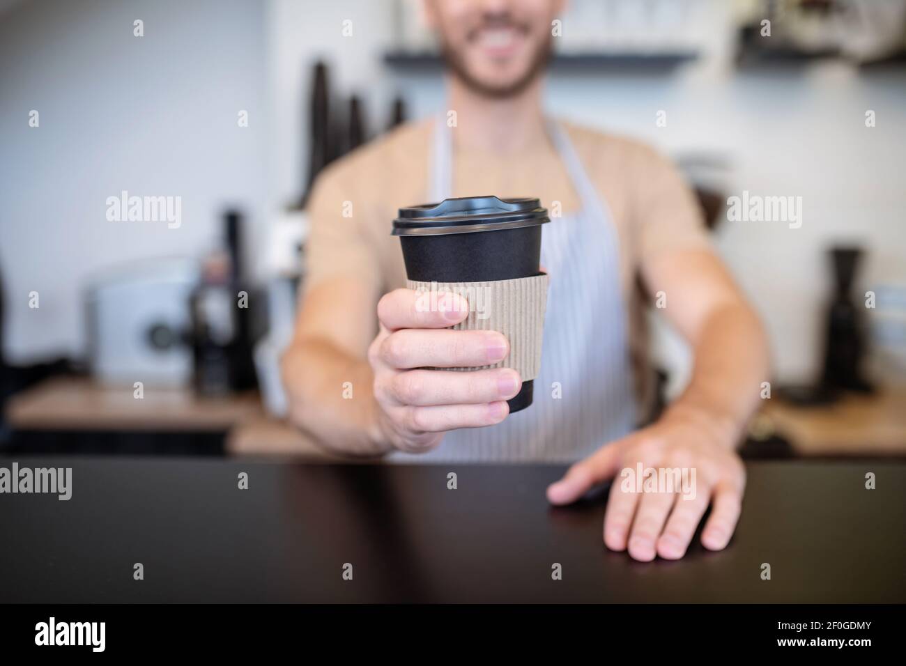 Coffee in the outstretched hand of barista Stock Photo