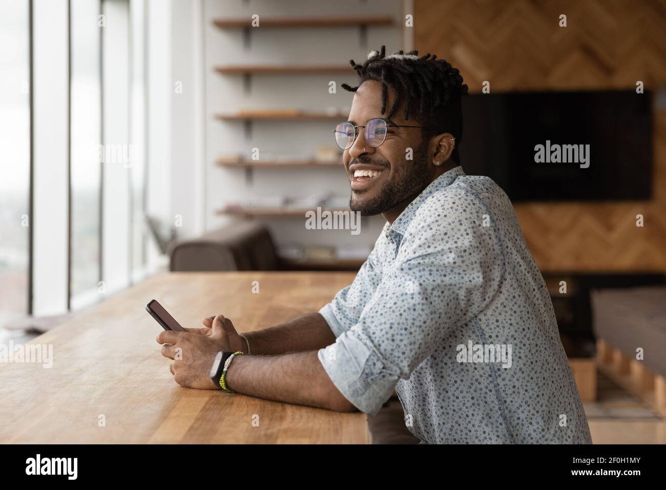 Close up smiling African American man distracted from phone Stock Photo