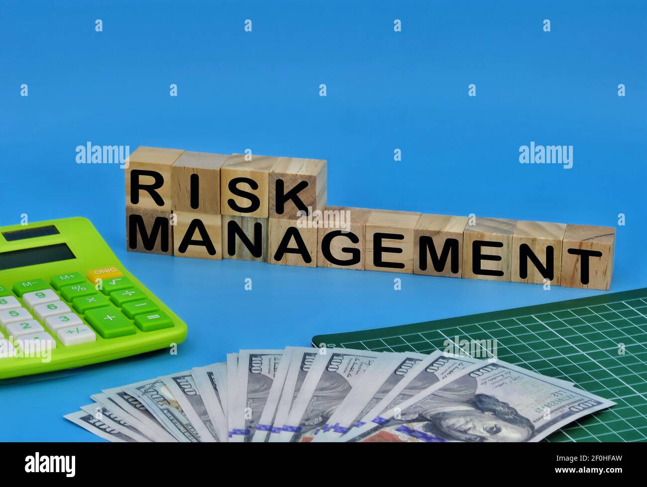 Layout of graph pad, fake money, calculator and wooden cube with text