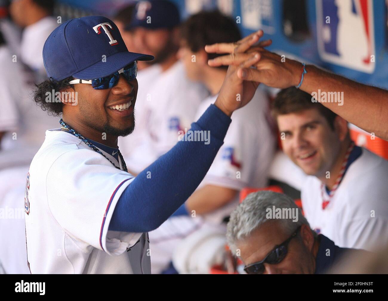 Texas Rangers' Elvis Andrus smiles in the dugout after he scored