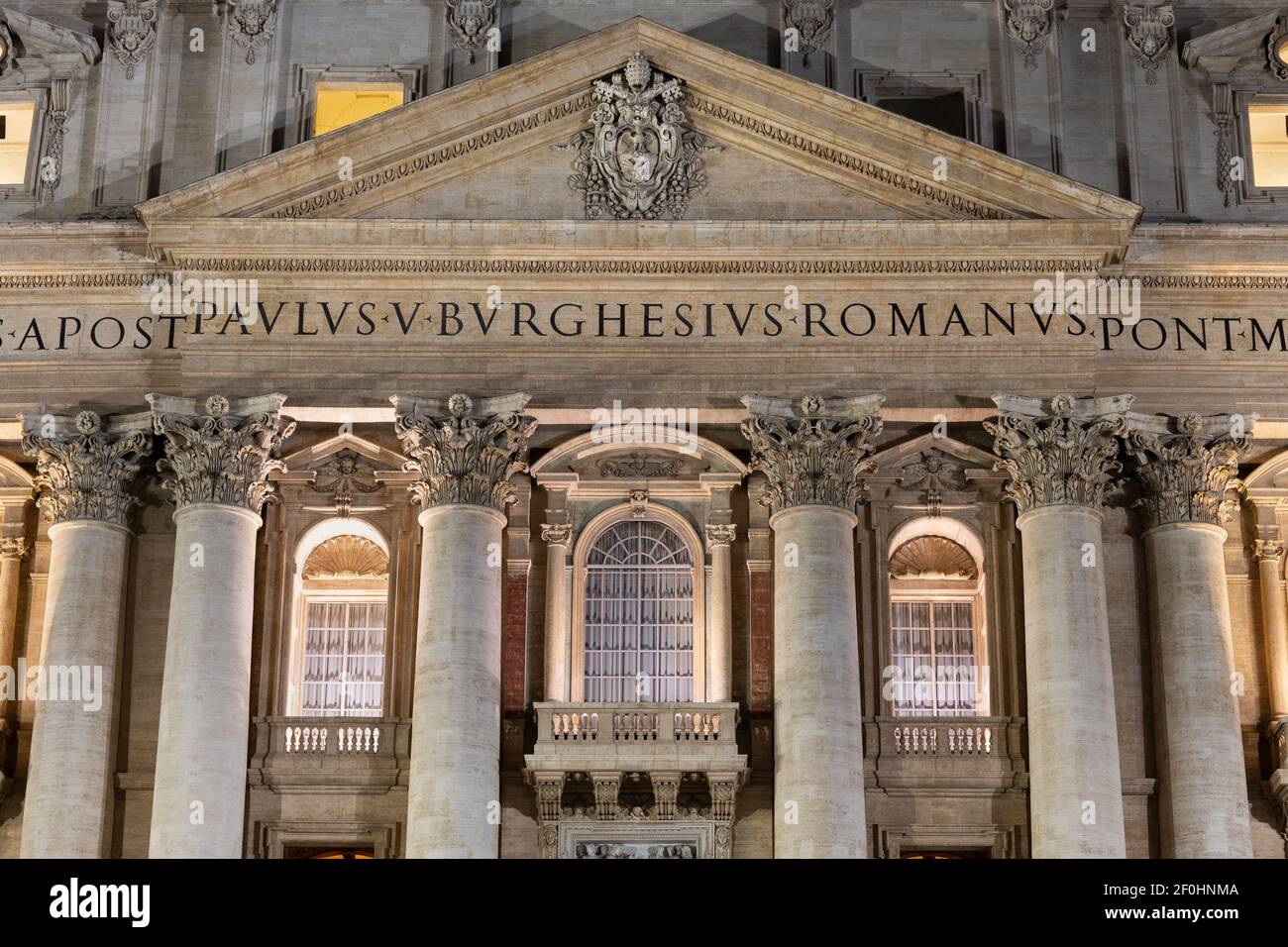 Pediment and Pope window with balcony in Papal Basilica of Saint Peter in the Vatican at night, Rome, Italy Stock Photo