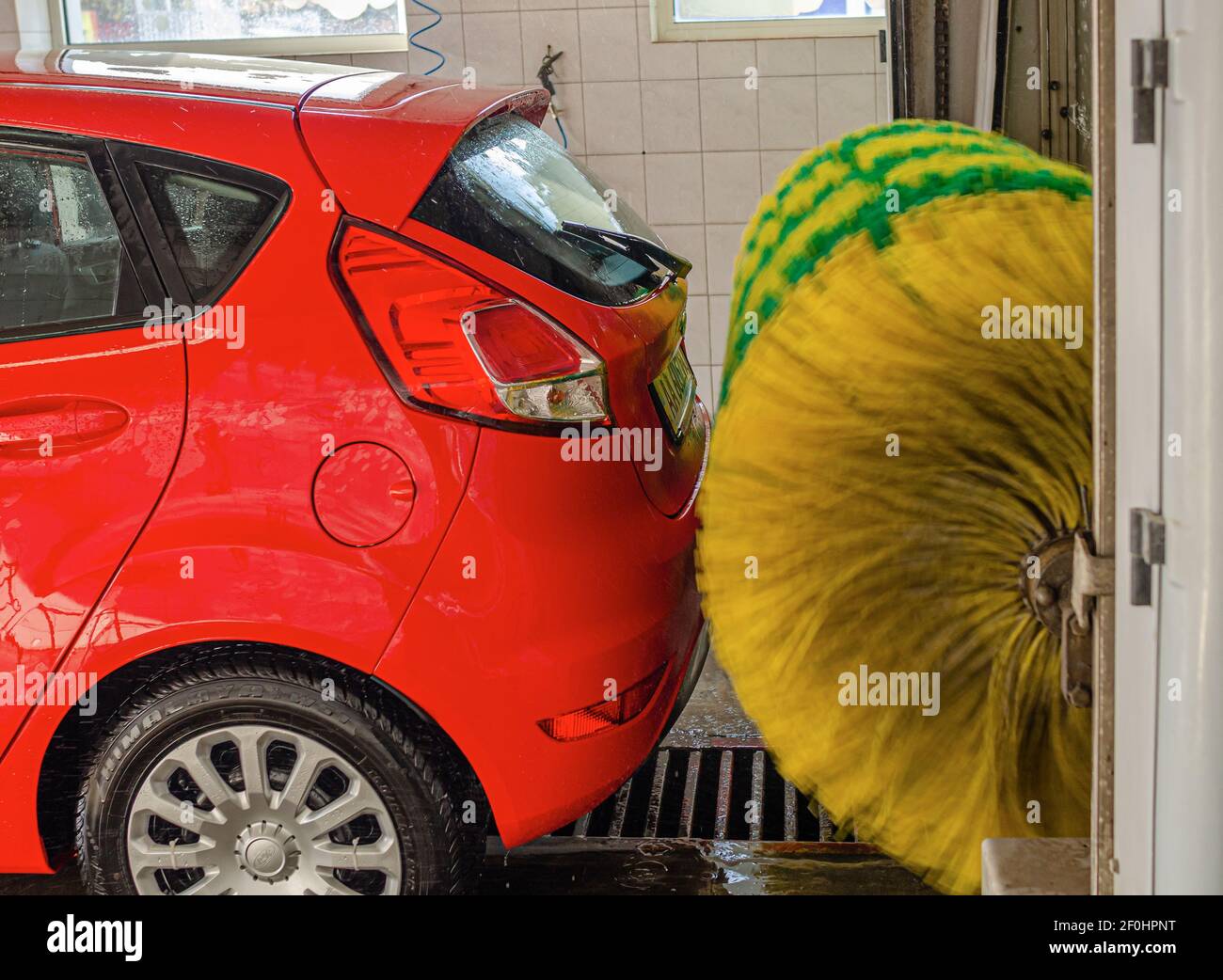 Red car at an automatic car wash. Stock Photo