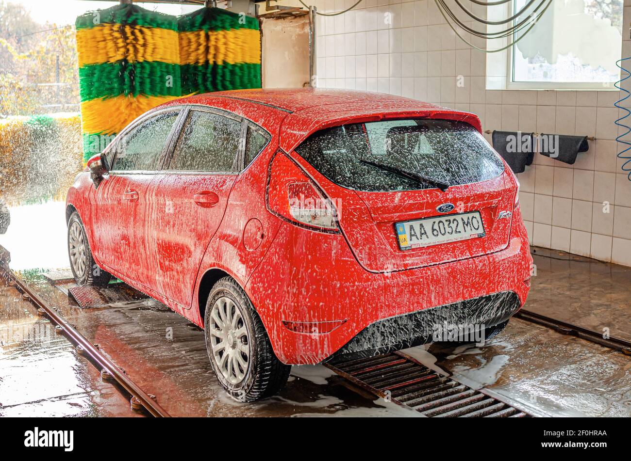 Red car at an automatic car wash. Stock Photo