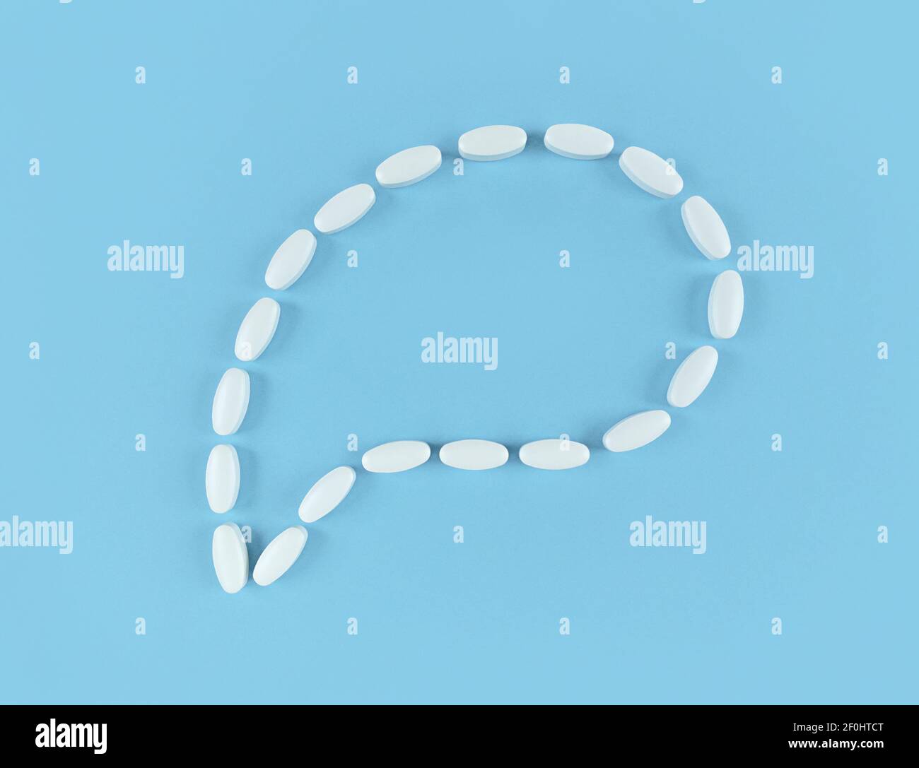 Speech bubble made from white tablets on blue backdrop with copy space. Stock Photo