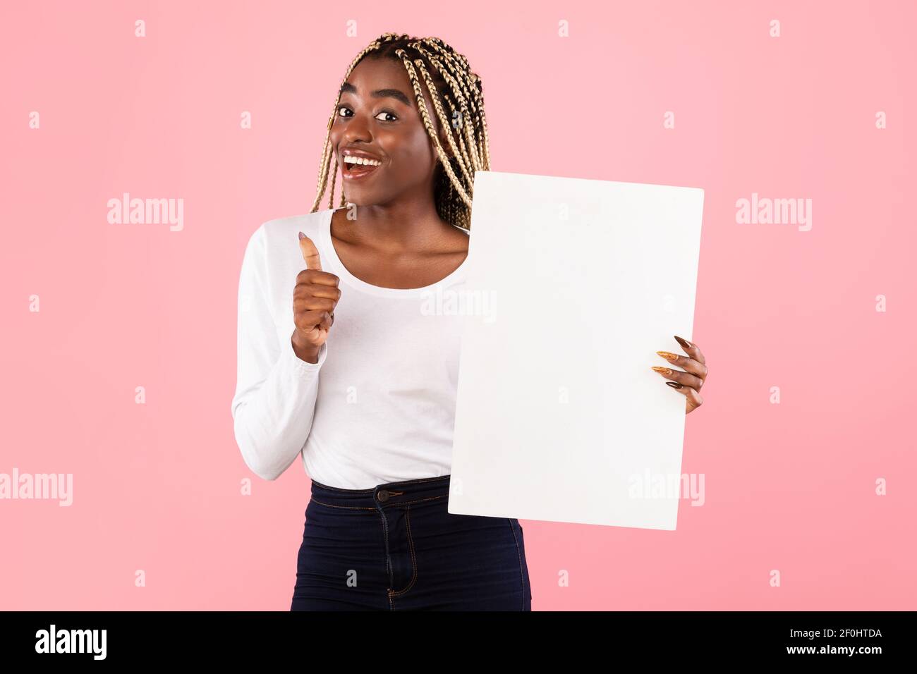 Black woman holding blank white advertising billboard showing thumbs up Stock Photo