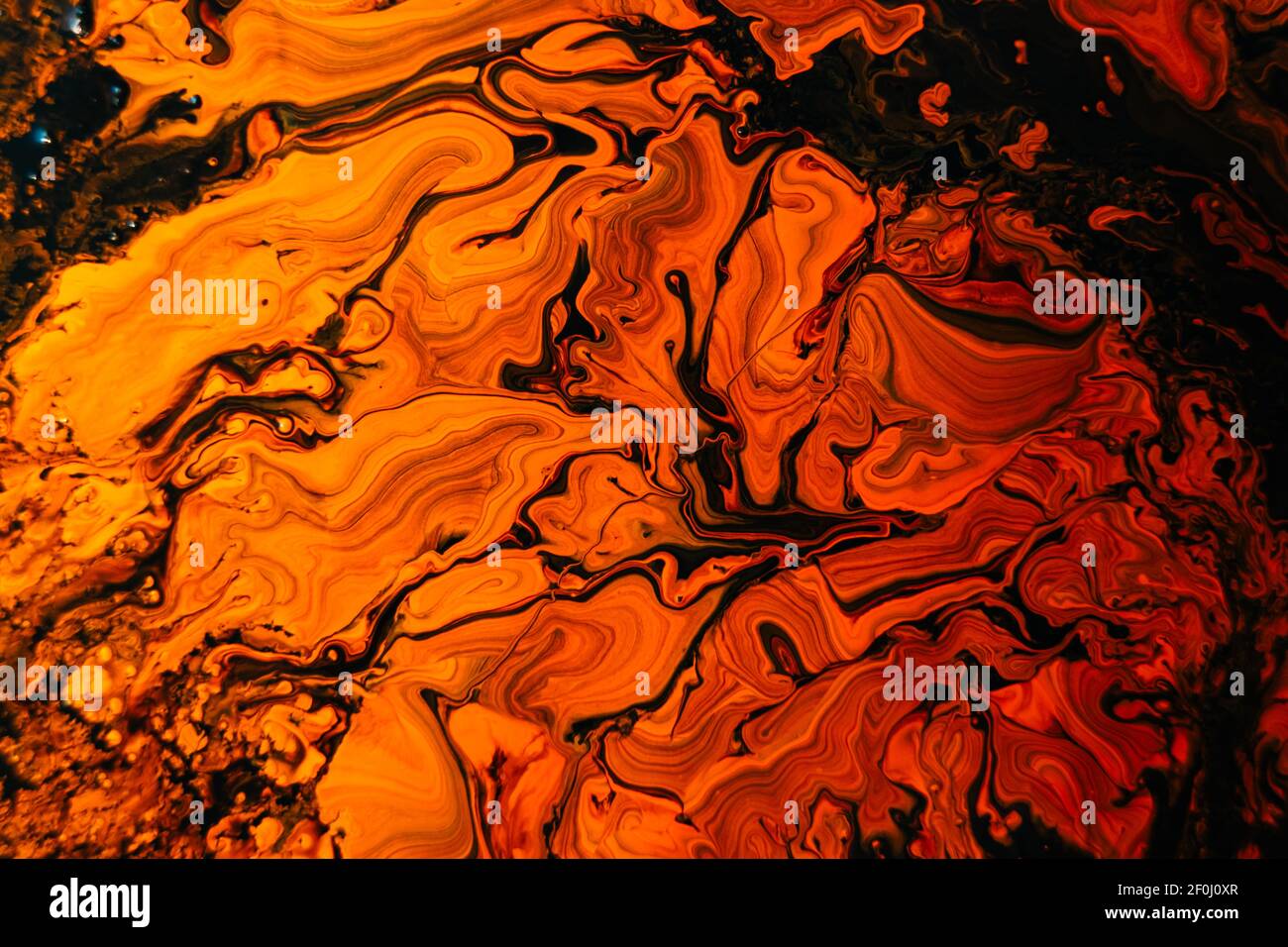 Background With Mixed Liquid Black And Orange Paints. Abstract Fluid