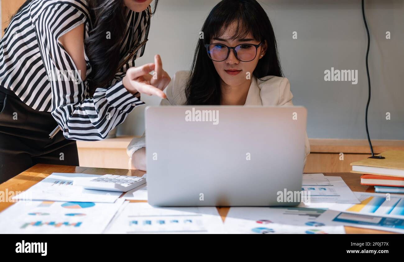 Business professionals. Group of young confident business people analyzing data using computer in the office. Stock Photo