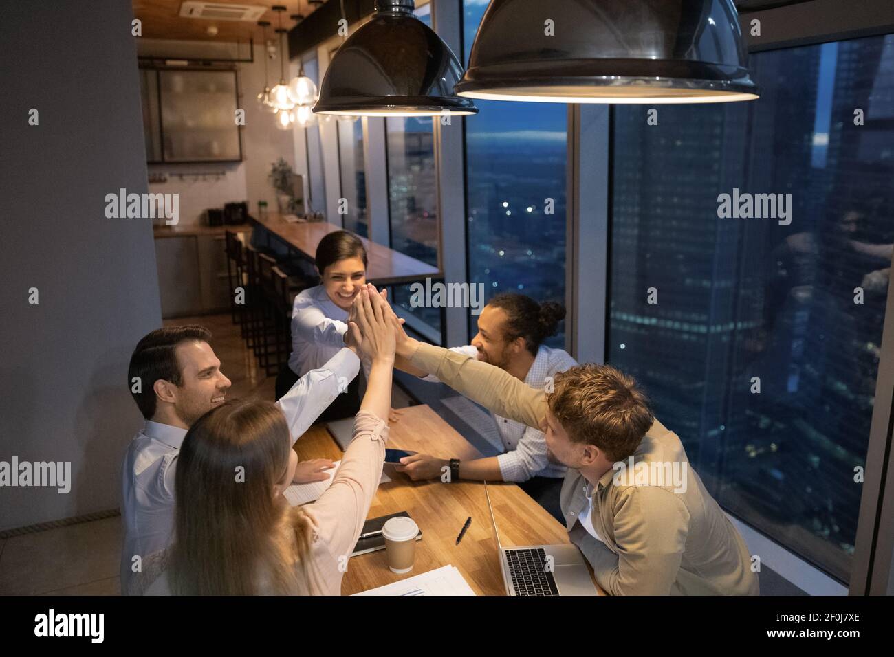 Top view diverse employees giving high five at late meeting Stock Photo ...