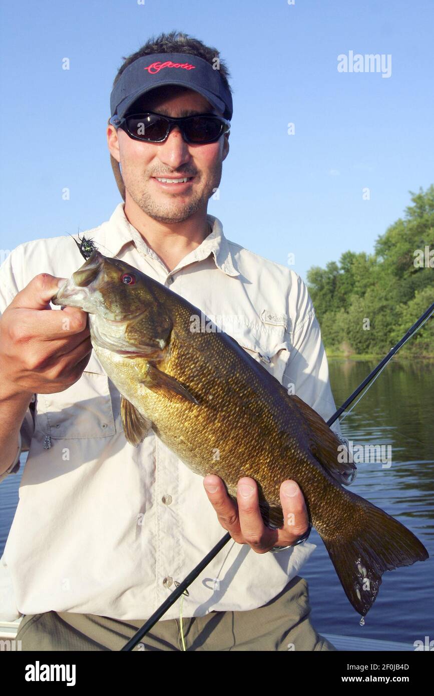 Flyfishing guide Ouitdee Carson holds a 15inch smallmouth bass he