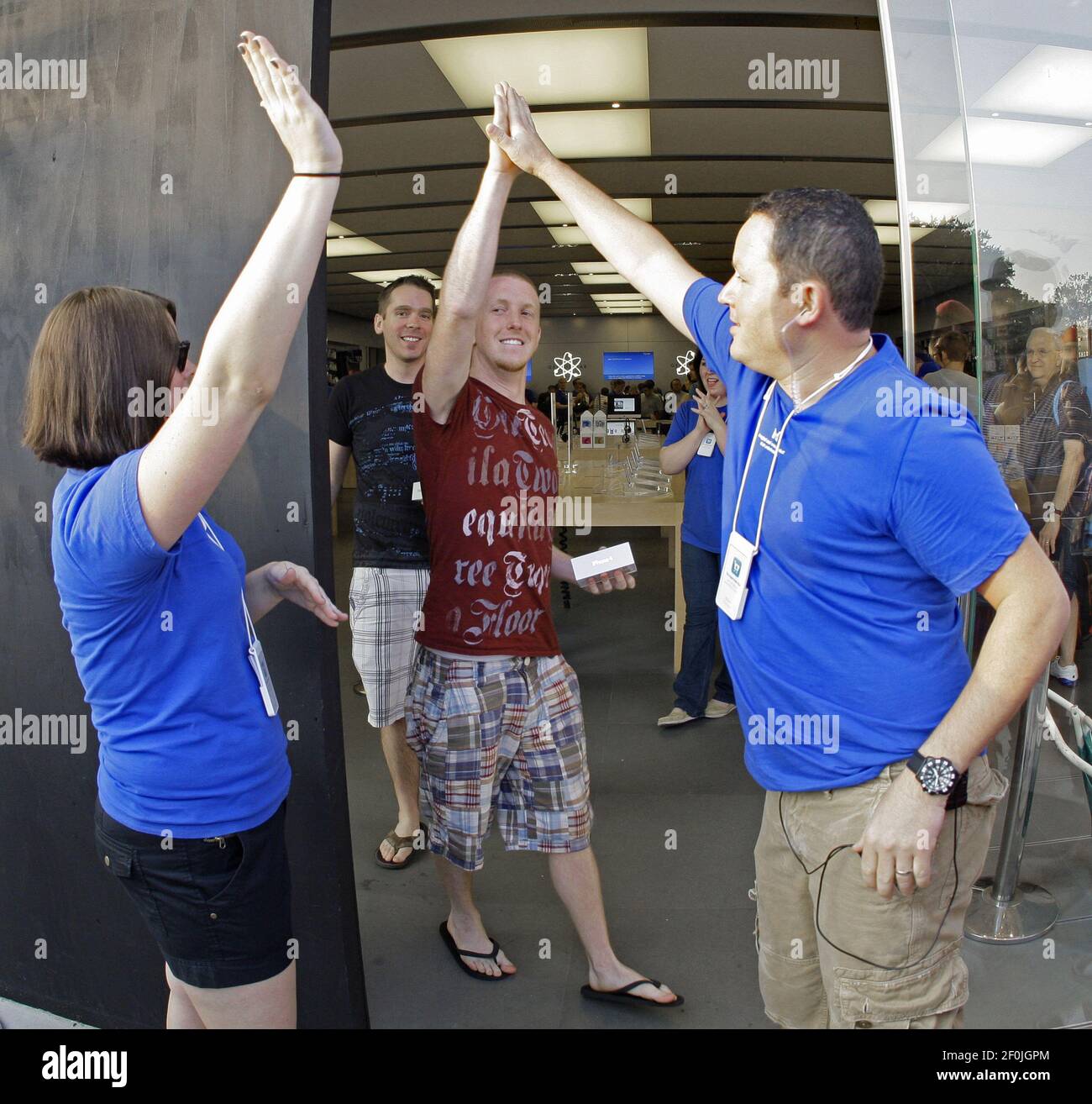 It only took ten minutes for Cody Lusby, foreground center, and friend Justin Franklin (rear, both from Saginaw) to be the first out of the door with their new iPhone 4Gs as they high five Apple Store staff at University Village in Fort Worth, Texas, Thursday, June 24, 2010. (Photo by Paul Moseley/Fort Worth Star-Telegram/MCT/Sipa USA) Stock Photo