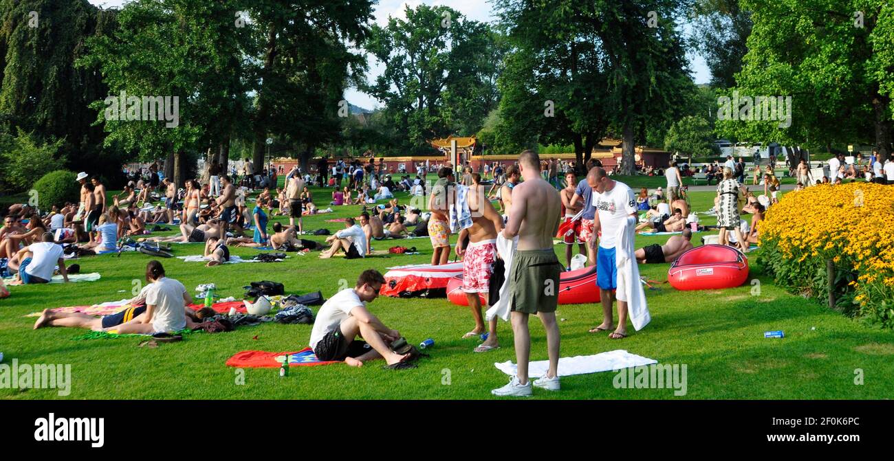 Sumertime at the boarder of lake Zürich: Masses of peoples relaxing, grilling and enjoying the sunshine in the chines garden lake park Stock Photo