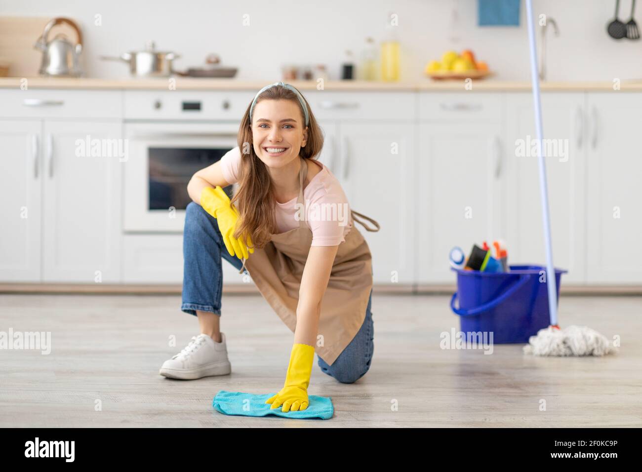 https://c8.alamy.com/comp/2F0KC9P/house-keeping-concept-happy-young-woman-wiping-floor-in-kitchen-wearing-rubber-gloves-using-cleaning-supplies-2F0KC9P.jpg