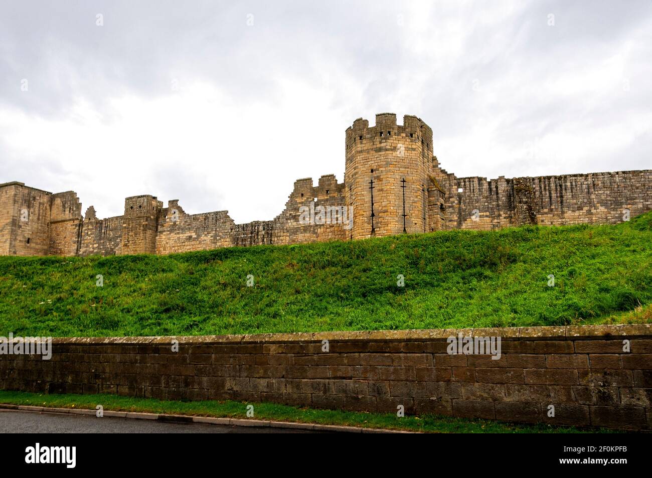 The 13th century Grey Mare's Tail Tower in the centre of the east curtain wall of Warkworth Castle with the ruins of Montagu Tower and the wellhouse Stock Photo