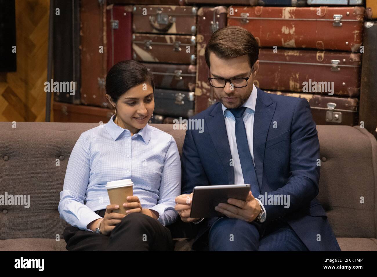 Close up diverse employees looking at tablet screen, discussing project Stock Photo