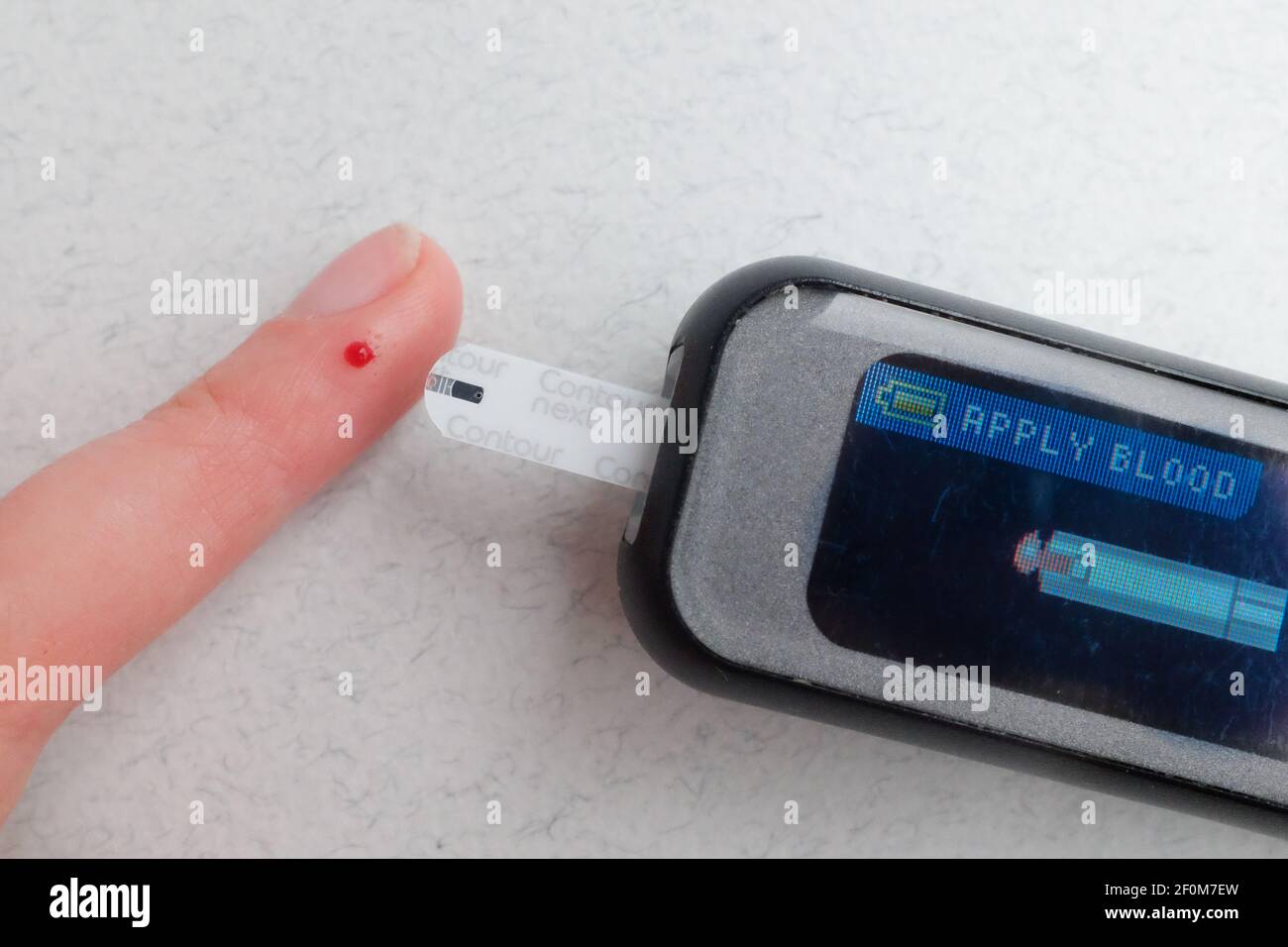A woman with Type 1 diabetes checks her blood sugar with a finger prick