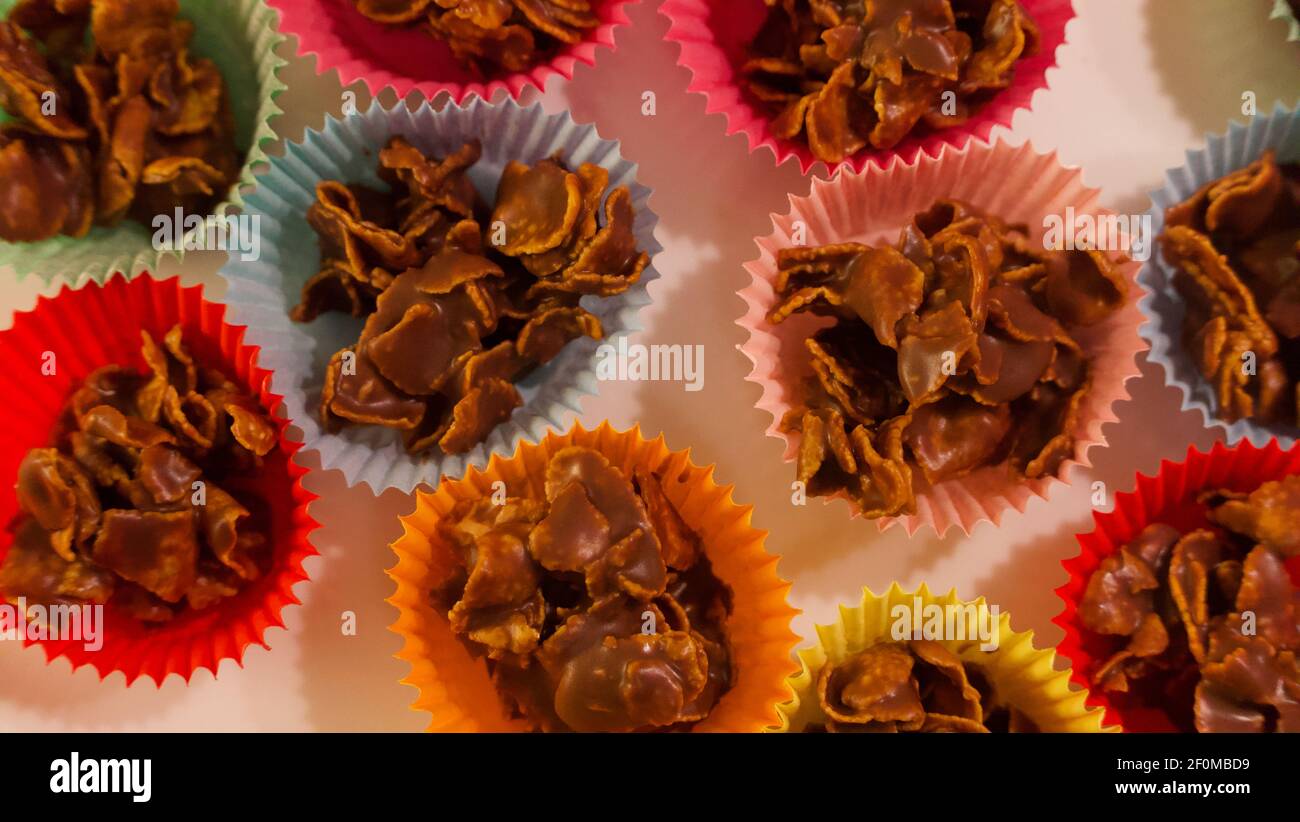 Full frame image of chocolate crispy cakes in coloured paper cases Stock Photo