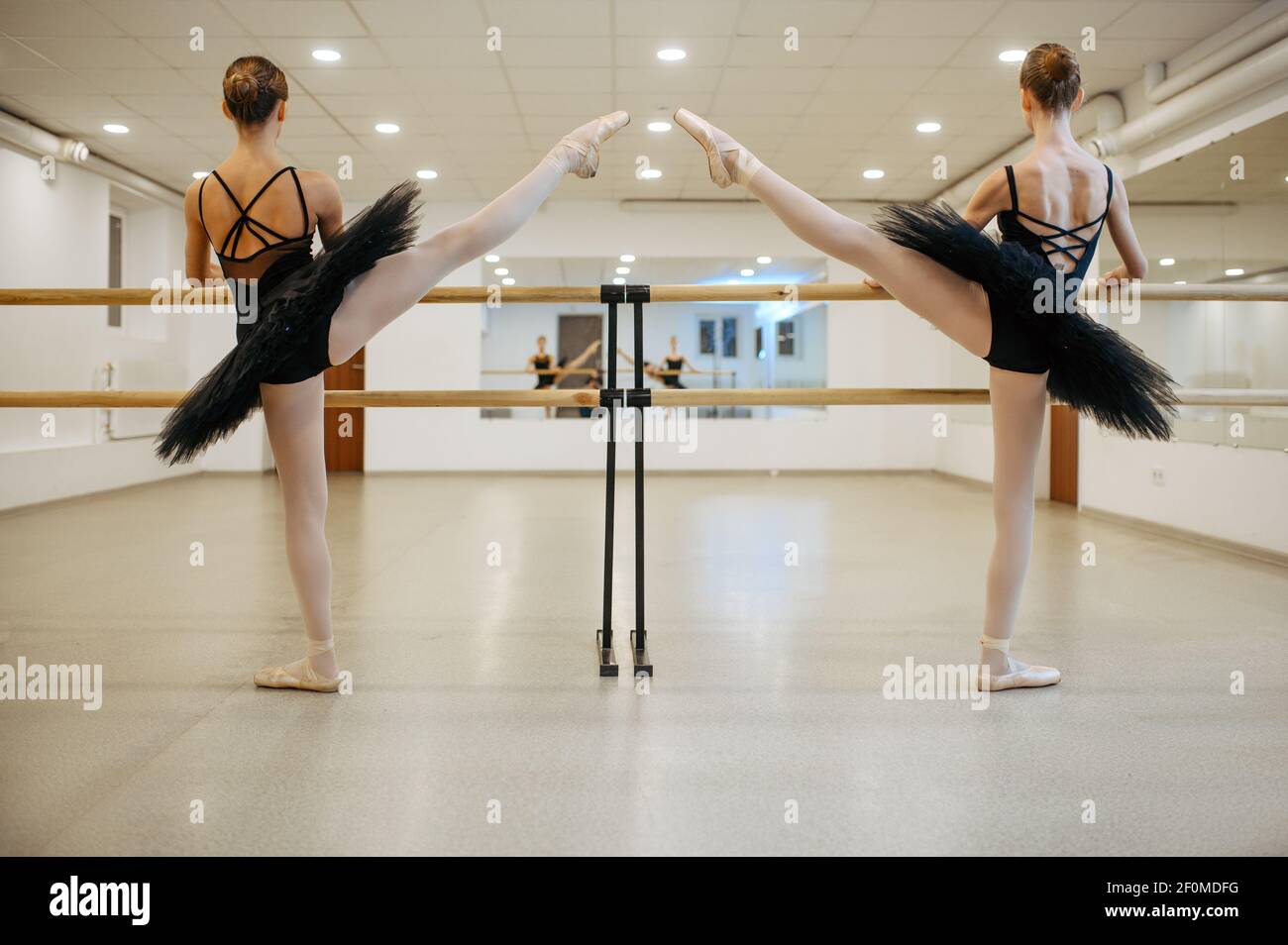 Elegant teen ballerinas, stretching at the barre Stock Photo