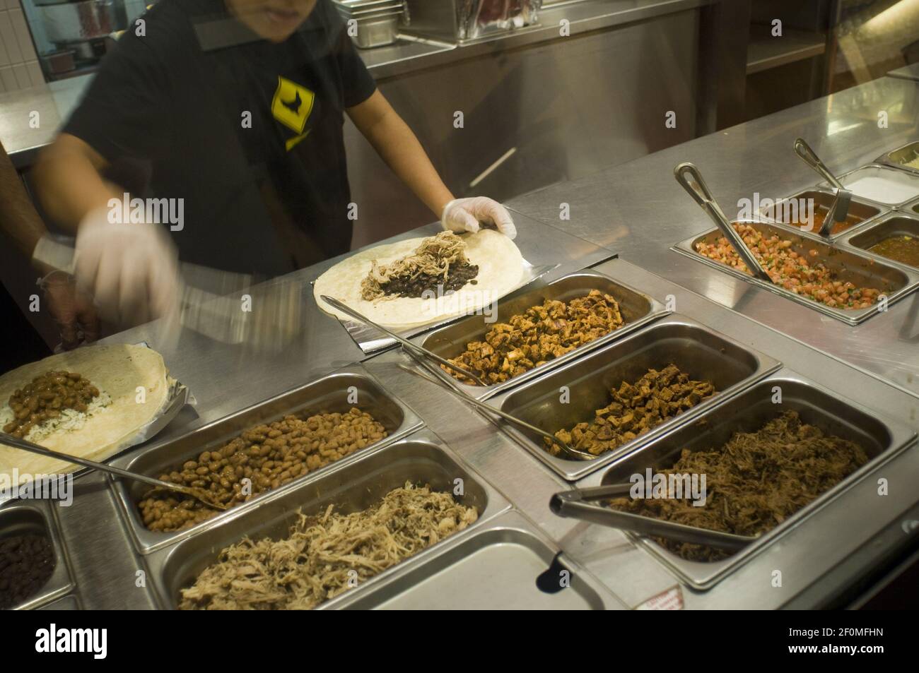 Workers prepare burritos at a Chipotle Mexican Grill in Midtown in New York  on Monday, December 7, 2009. Shares of Chipotle Mexican Grill plummeted on  reports of several customers contracting norovirus at